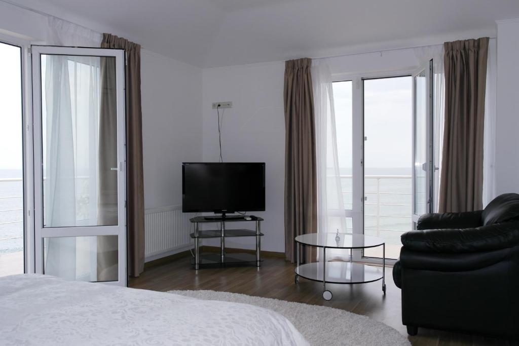 敖德萨别拉亚乌达查酒店的一间卧室配有一张床、一台电视和一把椅子