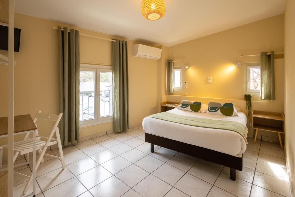 阿普特L'Aptois Hôtel的卧室配有一张床和一张桌子及椅子