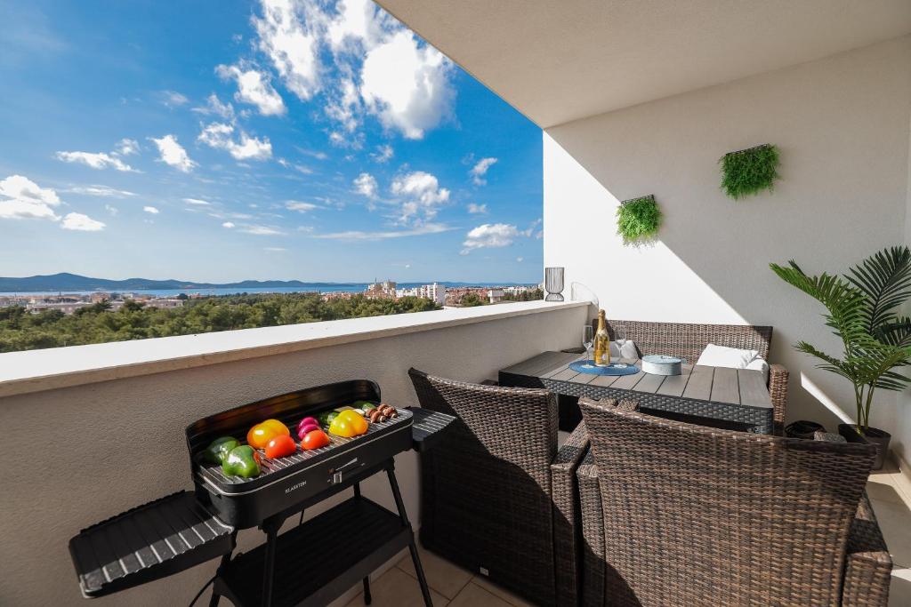 扎达尔Stella Maris 2BDR, balcony, sea view, garage, BBQ的阳台上放着一碗水果放在桌子上