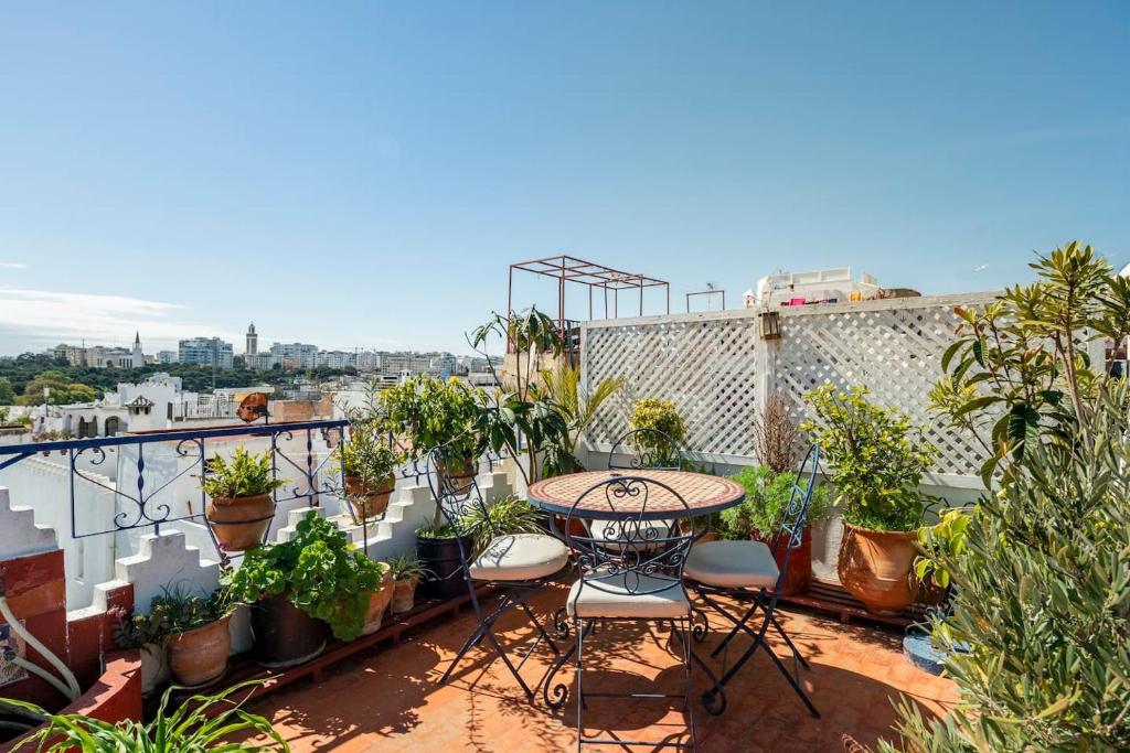 丹吉尔DAR YAMNA Maison typique Kasbah de Tanger的阳台配有桌椅和盆栽植物