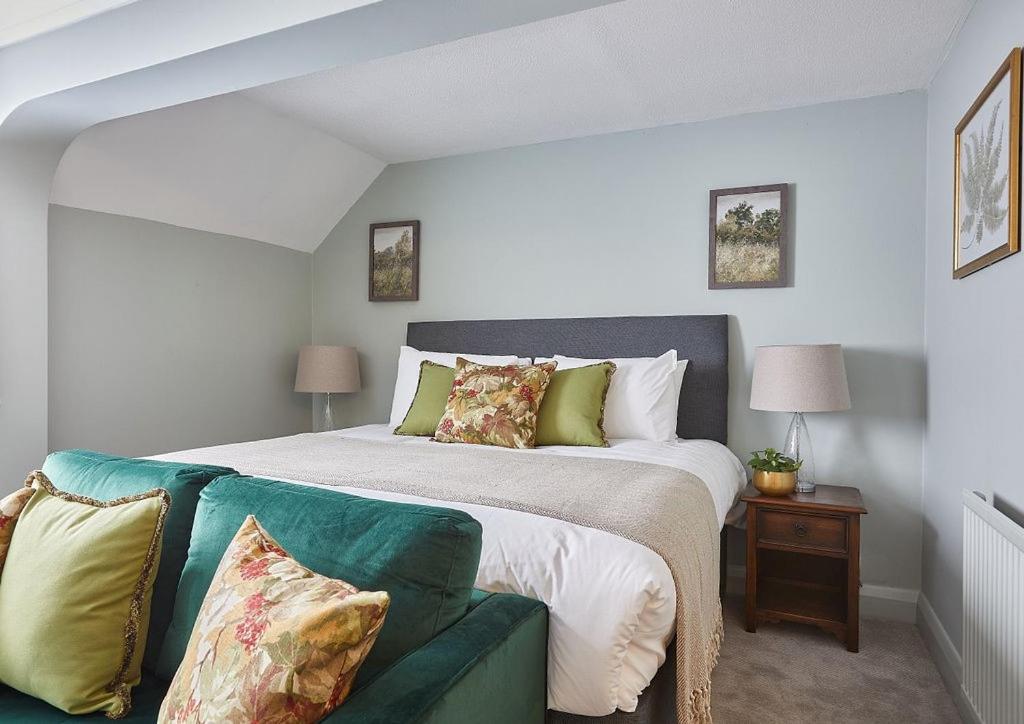 胡克The New Inn Heckfield的一间卧室配有一张床和一张绿色沙发