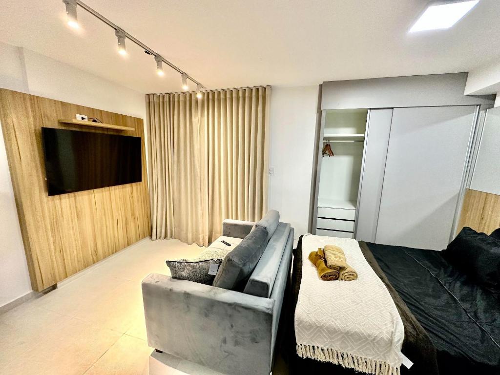 尤西德福拉Stúdio Elegance Central - Av Itamar Franco的客房设有床、沙发和电视。