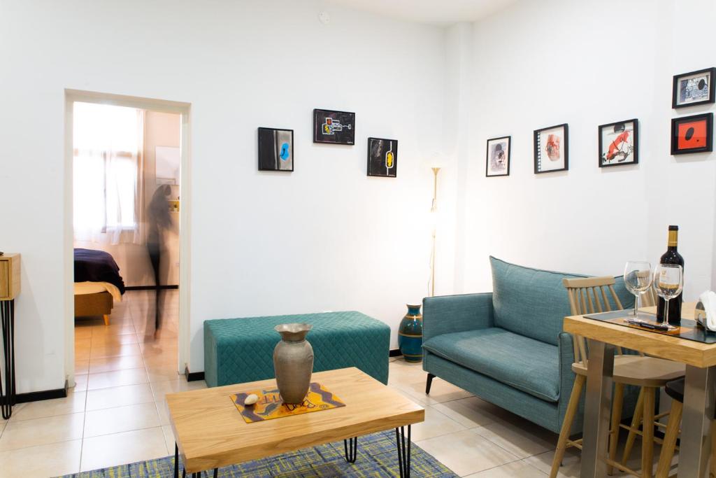 特拉维夫沙尔玛公寓的客厅配有蓝色的沙发和桌子