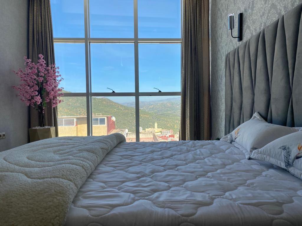 TaounateHotel Golden Star的一间卧室设有一张大床和大窗户