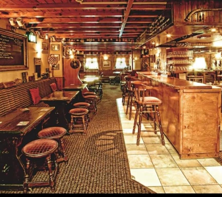 诺斯阿勒顿The Old Royal George的餐厅内带凳子和桌子的酒吧