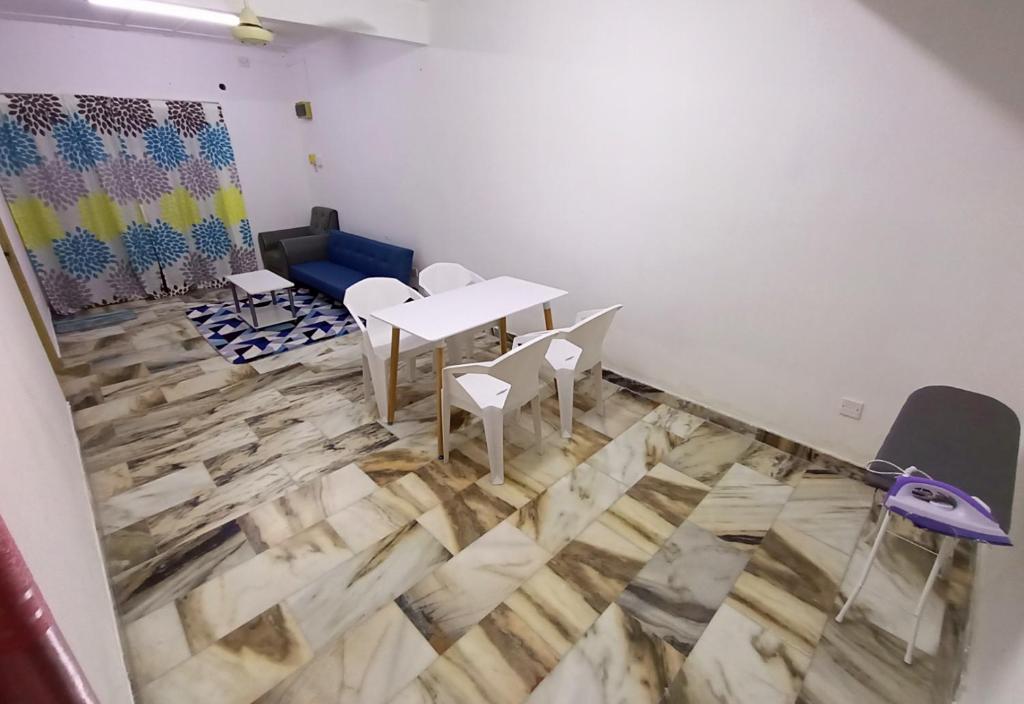 加央Simple Beseri Homestay的客房铺有木地板,配有桌椅。