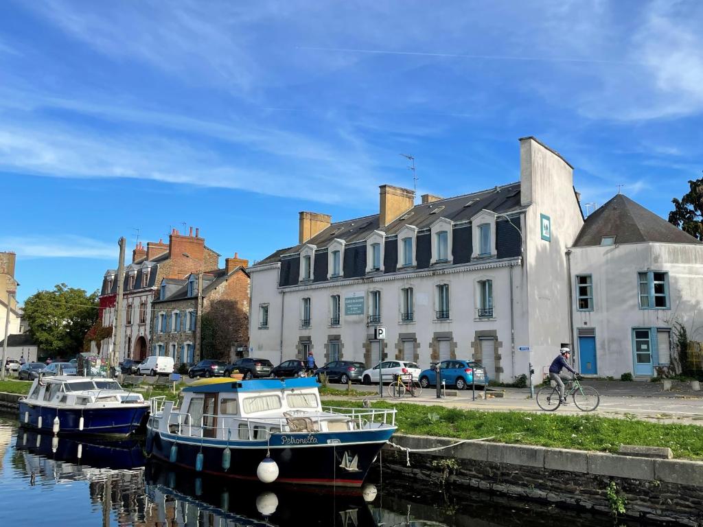 雷恩Hostel Rennes HI的两艘船停靠在运河上,运河上建有建筑物