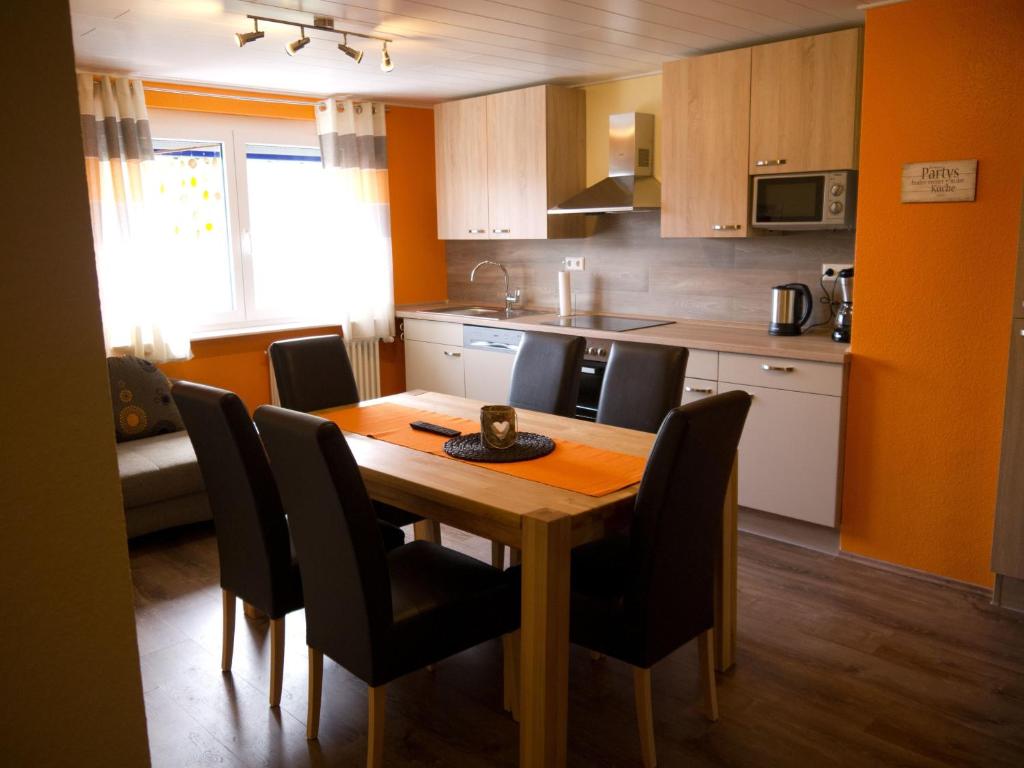 鲁斯特Ferienwohnung Bing的厨房配有木桌和黑色椅子