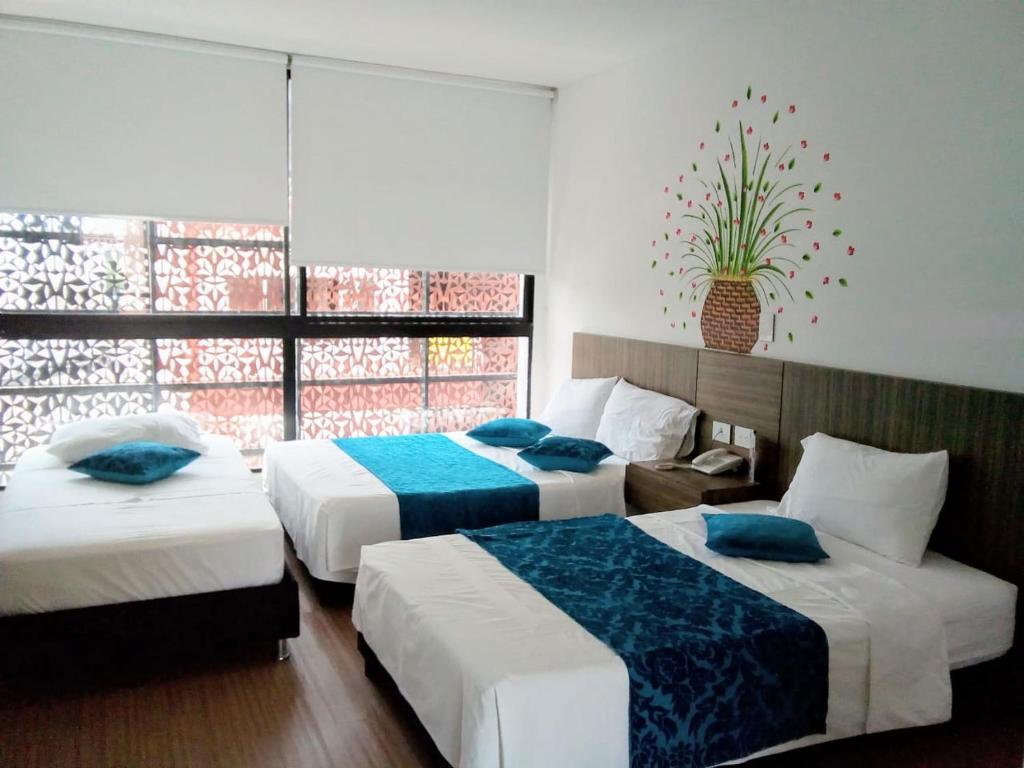 梅尔加Suite Sumapaz Hotel的酒店客房设有两张床和窗户。