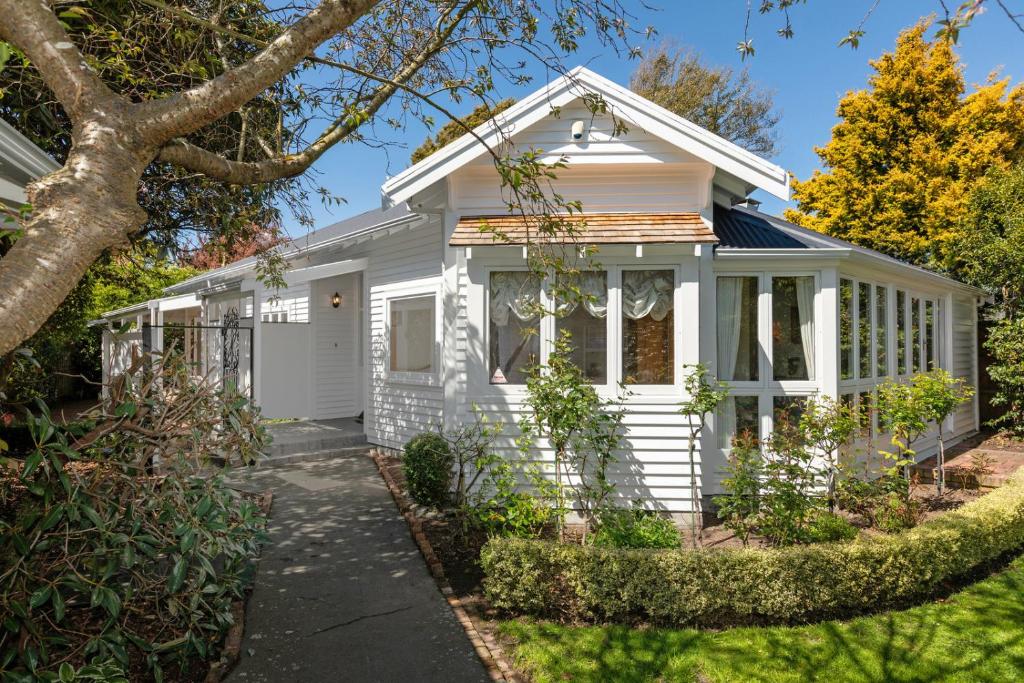 基督城Fendalton Villa - Christchurch Holiday Home的白色的小房子,设有门廊