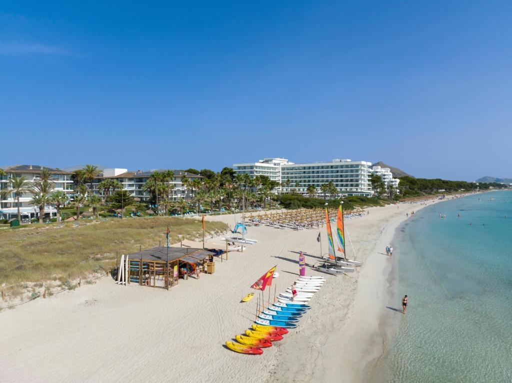 穆罗海滩Playa Esperanza Resort Affiliated by Meliá的海滩上设有椅子和遮阳伞,还有大海