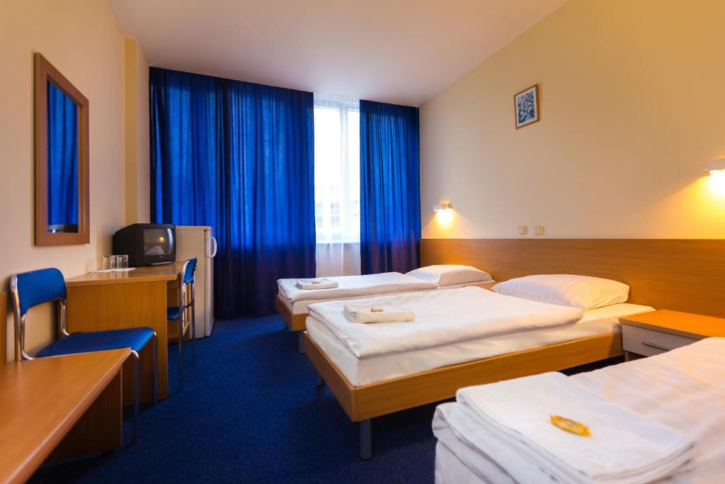 克拉科夫Dom Turystyczny Indigo的酒店客房设有三张床和电视。