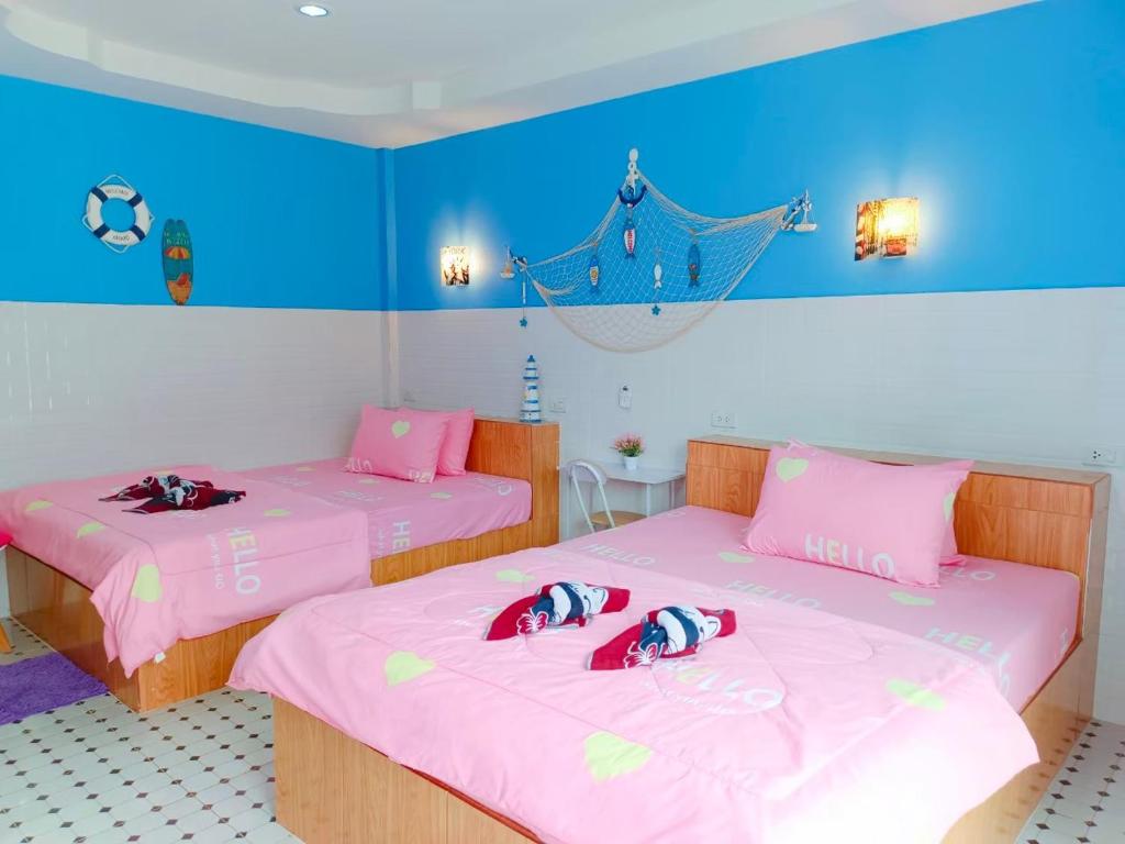 锡春Sichon Lalla Beach สิชล ลัลลา บีช的配有两张粉红色和蓝色墙壁的床铺