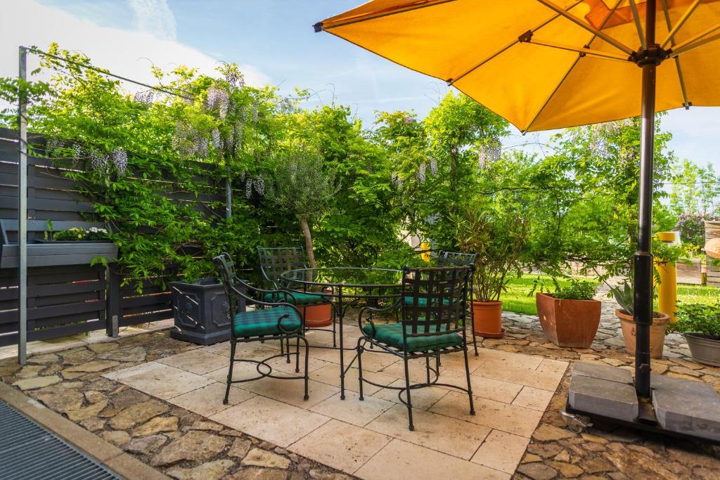 Gerbrunn伊丘之家公寓的庭院配有桌椅和遮阳伞。