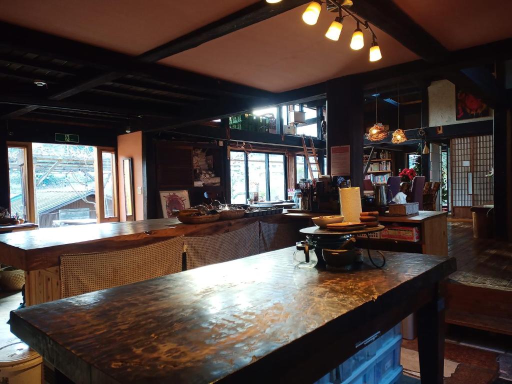 上野原市Yokomura Eco-Lodge的餐厅内带大型木台面的酒吧