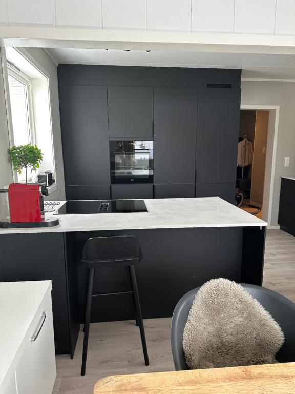 卡伯尔沃格Lofoten Kabelvåg-small apartment的厨房配有黑白柜台和凳子