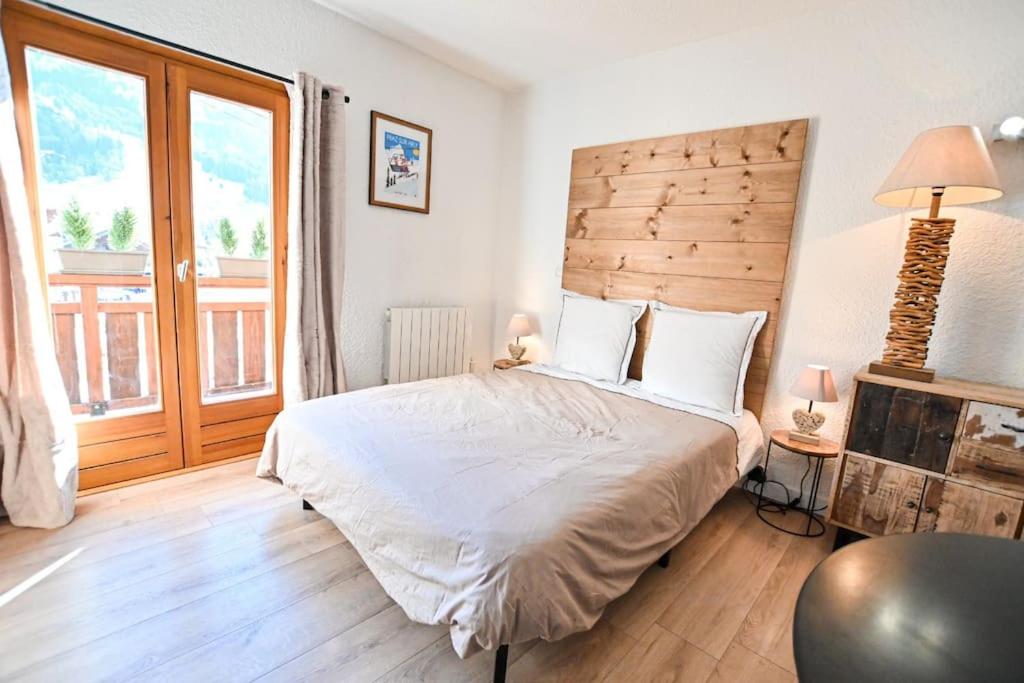 阿尔利河畔普拉兹Le balcon des neiges的一间卧室配有一张大床和木制床头板