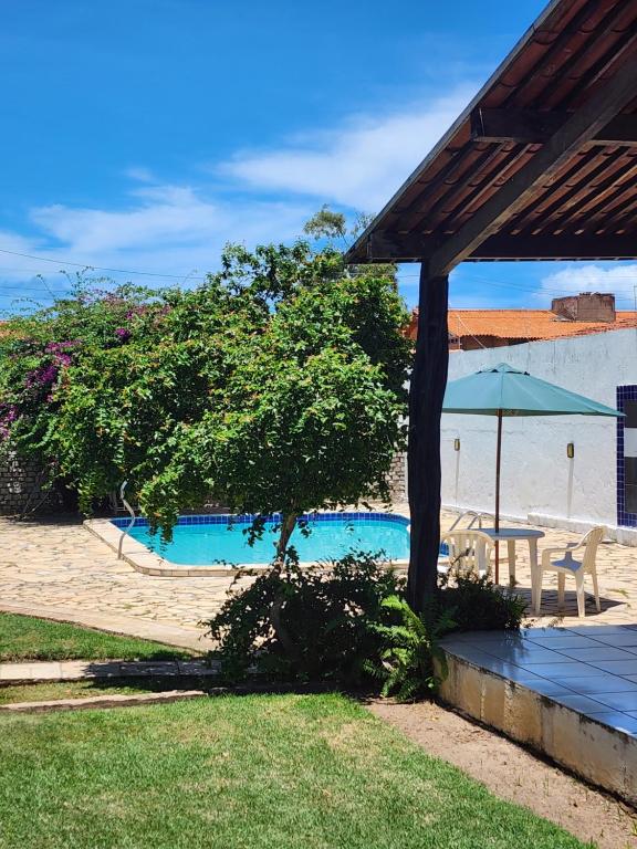 拉巴拉德纳圣安东尼奥Casa na Ilha da Crôa的一座带树和遮阳伞的游泳池