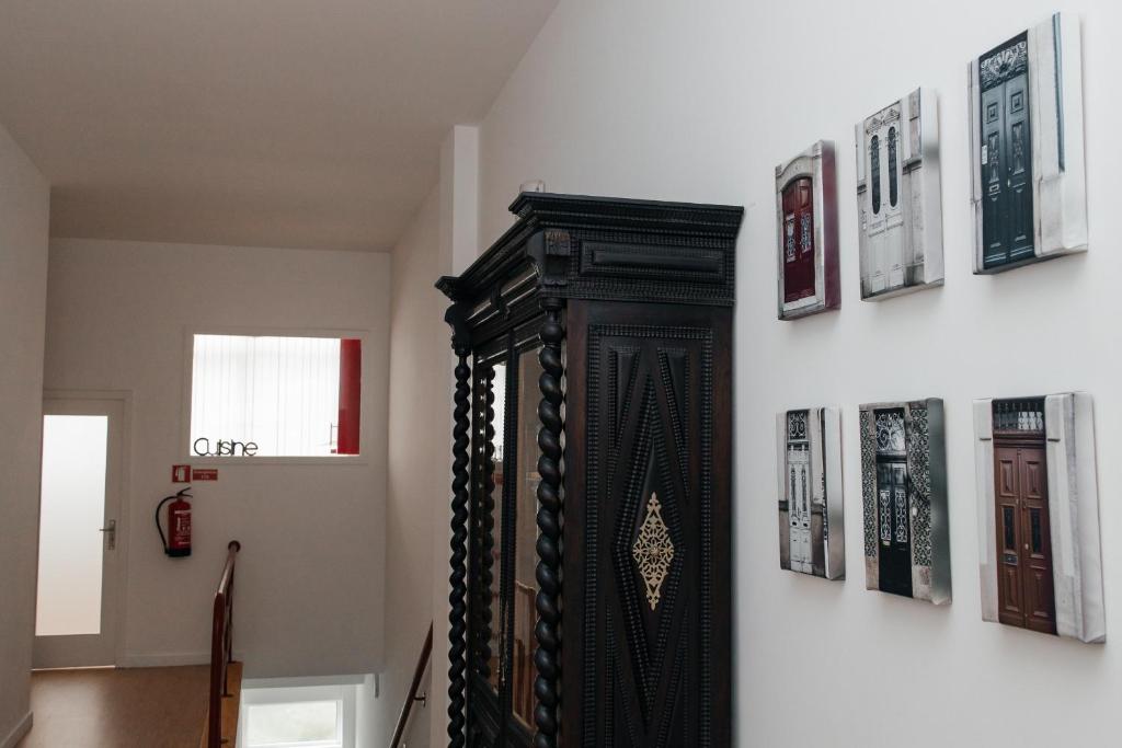 波尔图Júlio de Matos Guest House的墙上的黑色镜子,上面有照片
