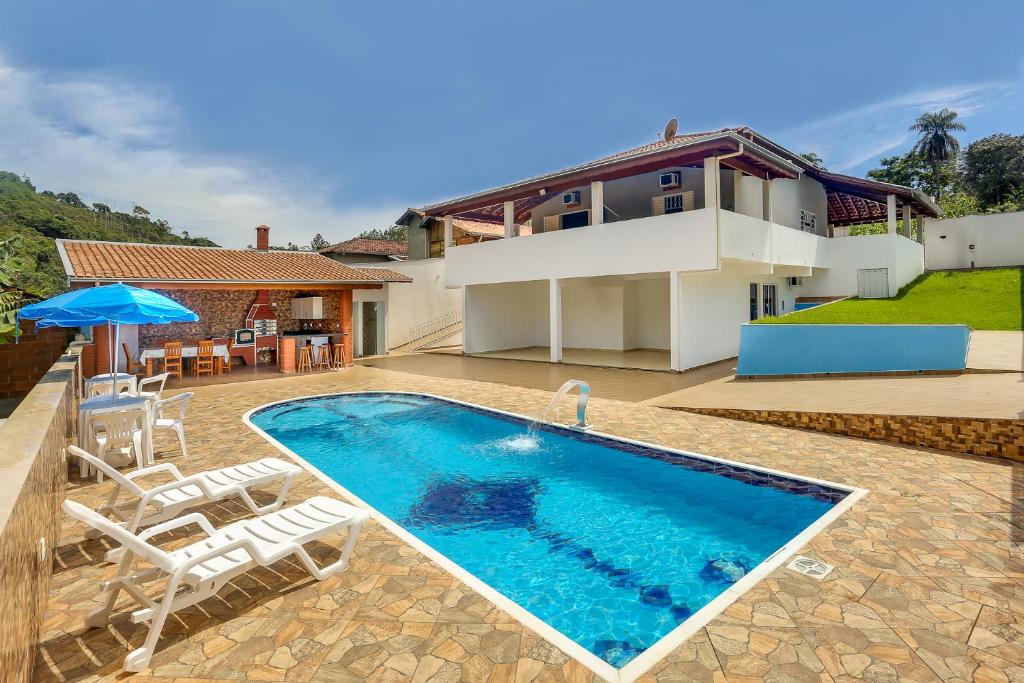 林多亚Casa São Luis的一个带椅子的游泳池以及一座房子