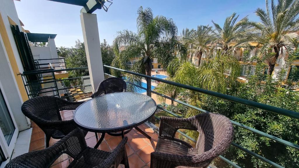 塔维拉Apartamento Monte da Eira by Homekeys的阳台配有桌椅和棕榈树。