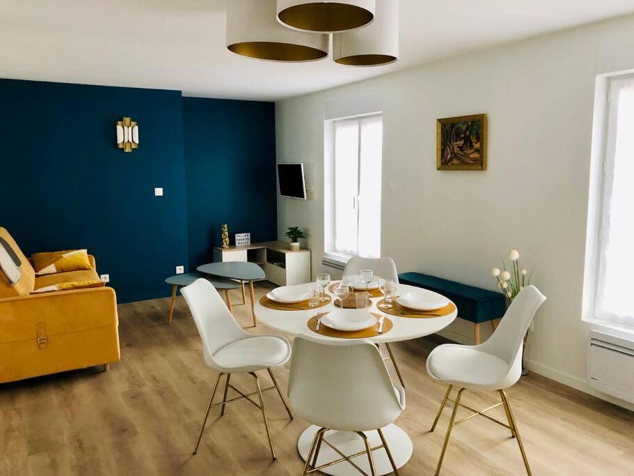 阿布维尔Maison Gabriel Appartement BULLE的一间带桌子和白色椅子的用餐室