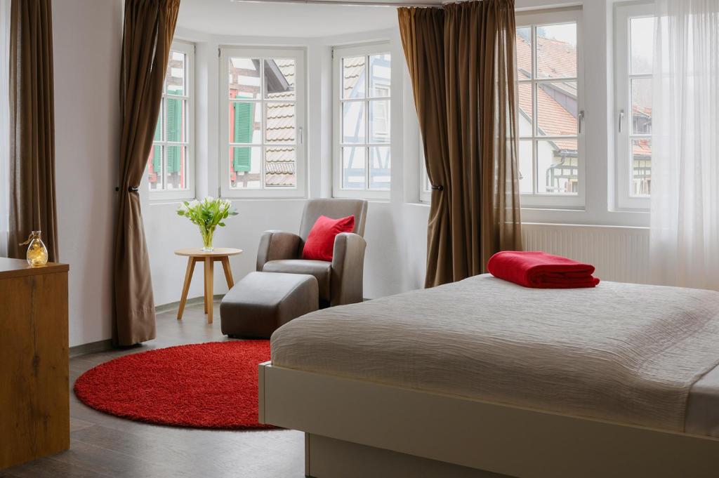 希尔塔赫Adler Schiltach Boutique Hotel und Restaurant的一间卧室配有一张床、一把椅子和窗户。