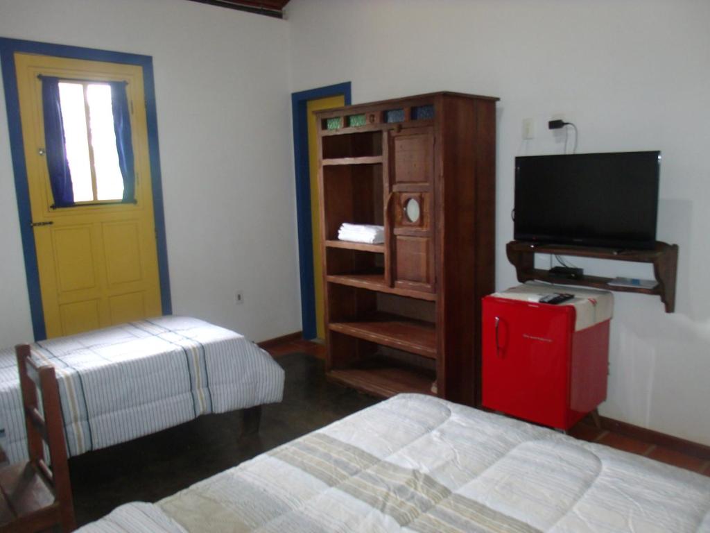 卡塔斯阿塔斯Pousada Ora Pro Nobis的卧室配有床、电视和门