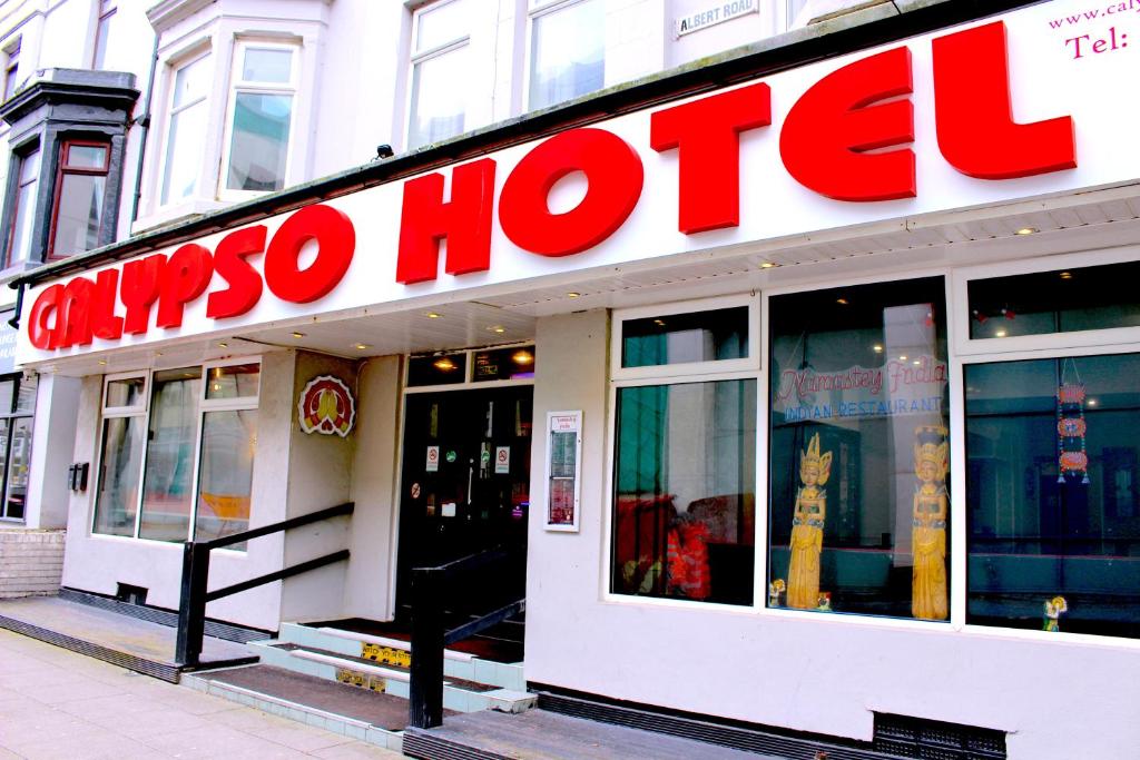 布莱克浦Calypso hotel Blackpool的建筑物一侧有红色标志的商店