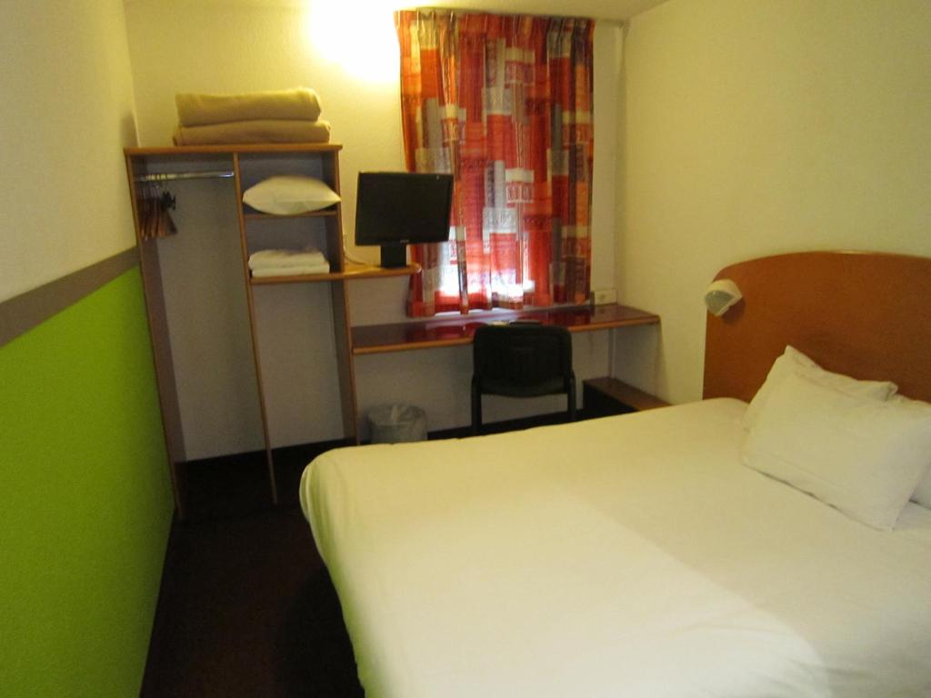 南特南特堡茹宫快捷酒店的配有一张床、一张书桌和一扇窗户的酒店客房