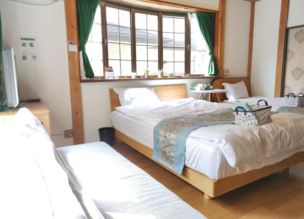 Kokubunji日久の宿的一间卧室设有两张床和窗户。