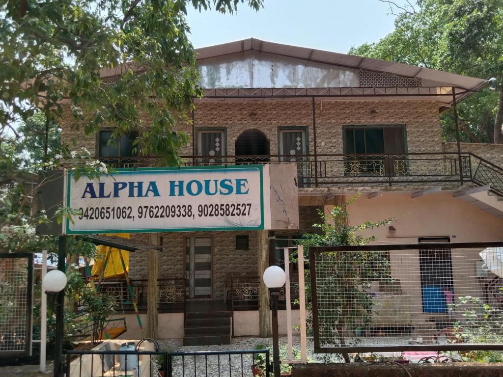 马泰兰Alpha House Matheran的带有读取阿尔法房屋标志的建筑