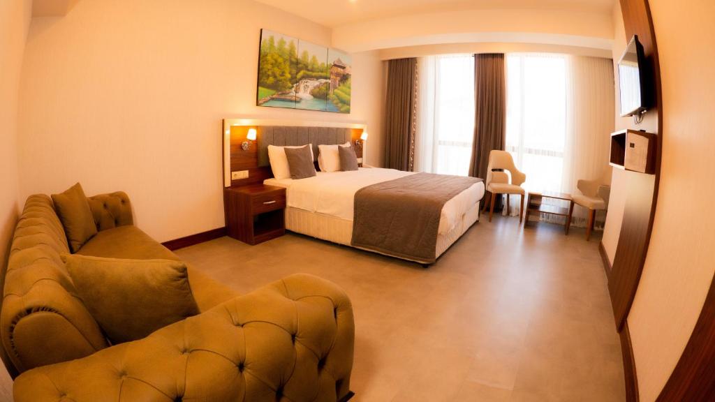 特拉布宗Deryaman Hotel Trabzon的酒店客房,配有床和沙发