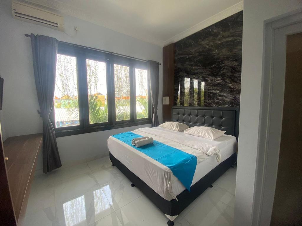 登巴萨巴厘梦幻科斯特尔酒店的一间卧室设有一张床和一个大窗户