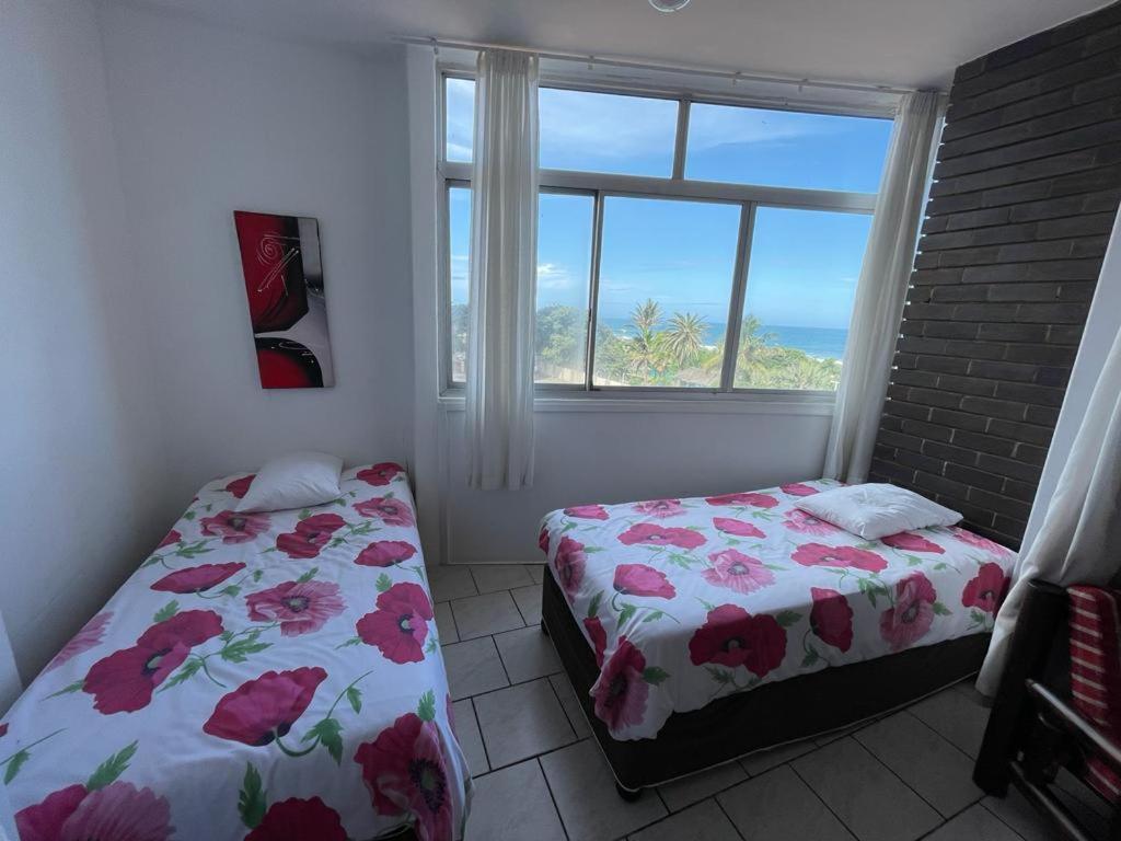 德班Amanzimtoti Beachfront Holiday Apartment , Flat No 23, Ezulweni的卧室在窗户前配有两张床