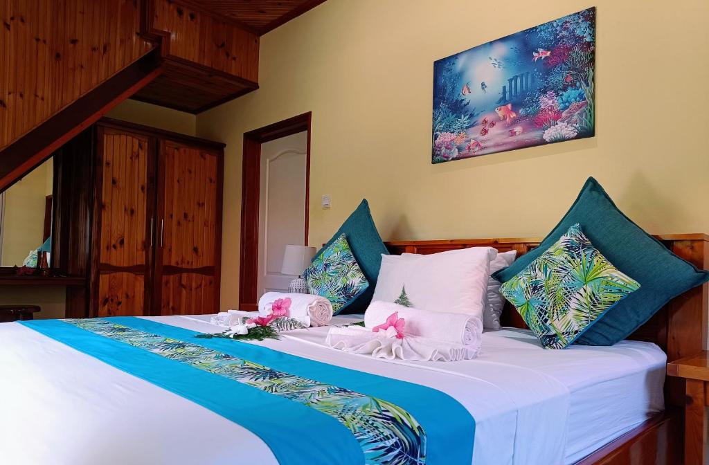 拉迪格岛Badamier Self-Catering的一间卧室配有一张带蓝色和白色枕头的床
