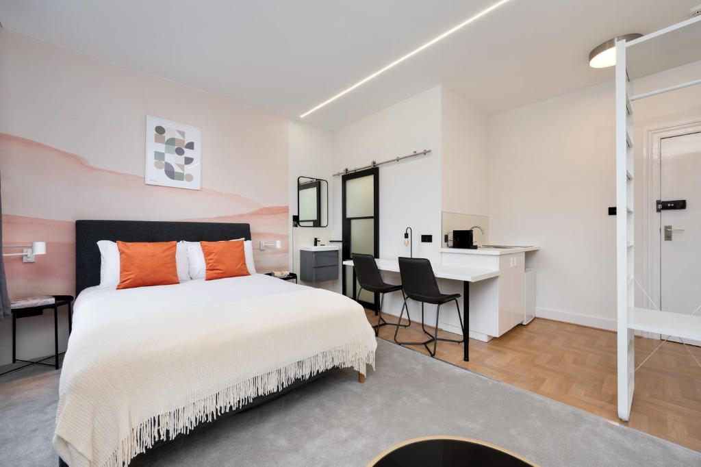 伦敦D8 House的一间卧室配有一张大床和一张书桌