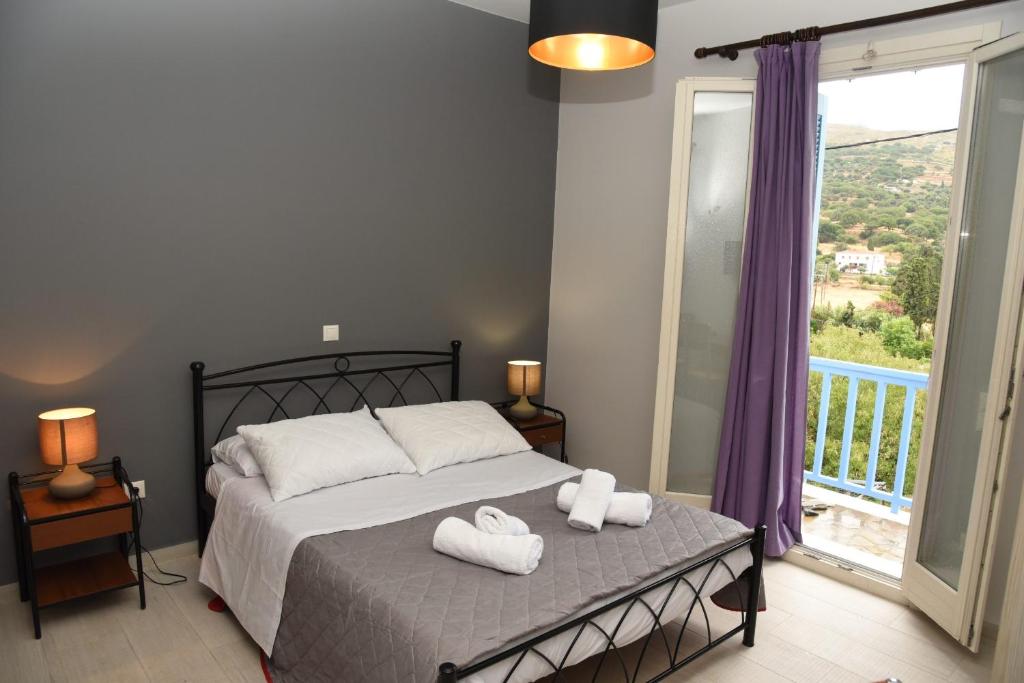 安德罗斯Andros Guesthouses的一间卧室配有一张床,上面有两条毛巾