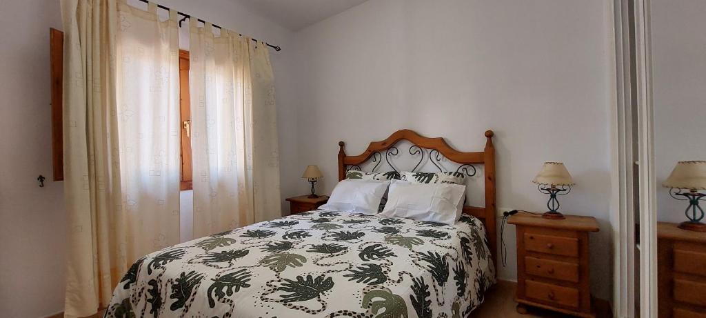下布雷尼亚Vv Los Balconcitos 31 Los Cancajos的一间卧室配有一张带绿色和白色棉被的床