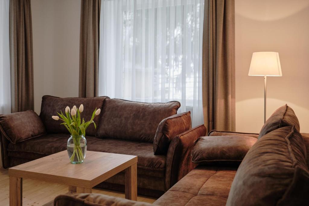 约纳瓦Jonavos alpakų svečių namai的客厅配有沙发和桌子