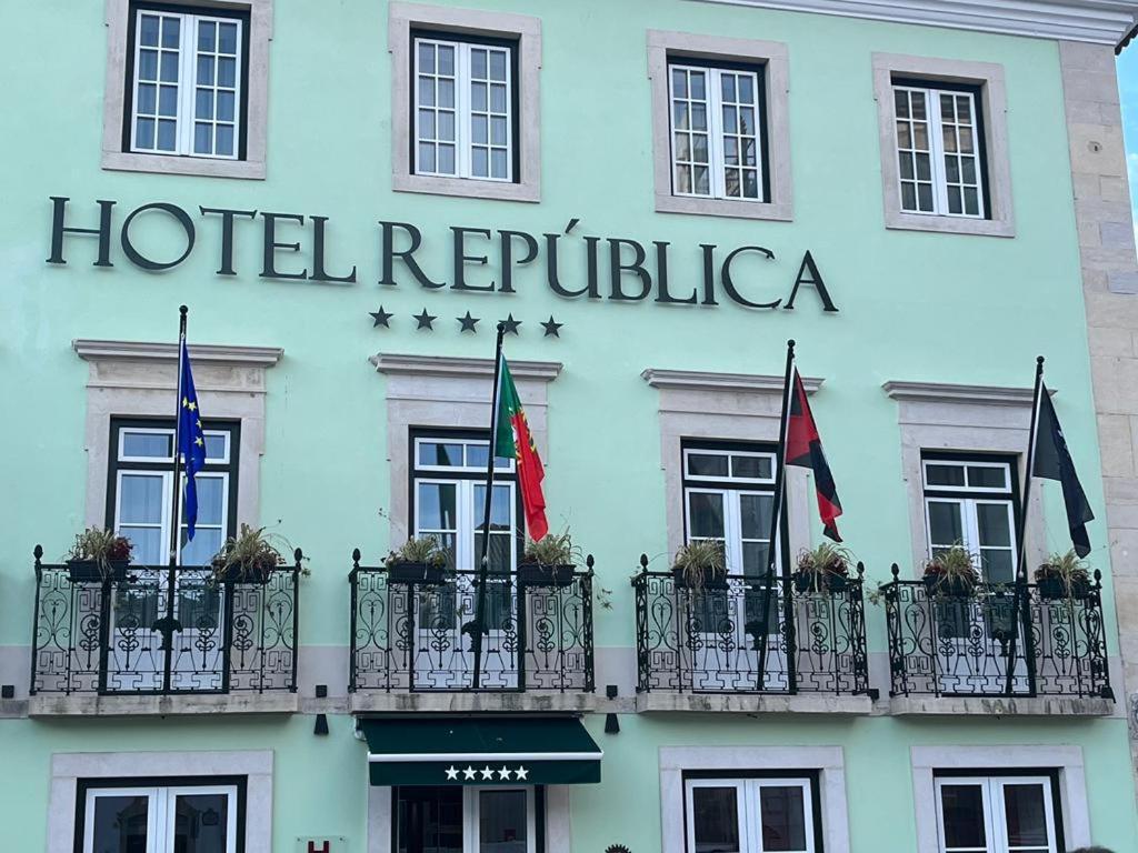 托马尔Hotel República Boutique Hotel的大楼前有旗帜的酒店