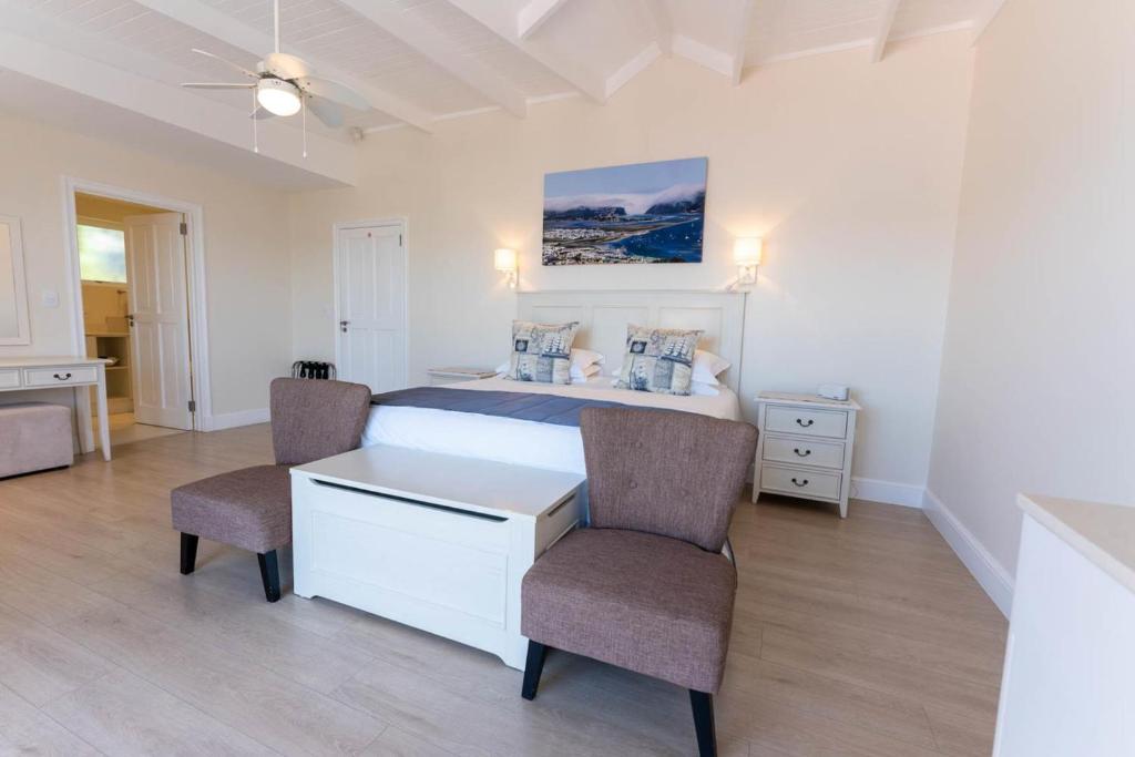 克尼斯纳Westhill Luxury Guest House的一间卧室配有一张带两把椅子和一张桌子的床。