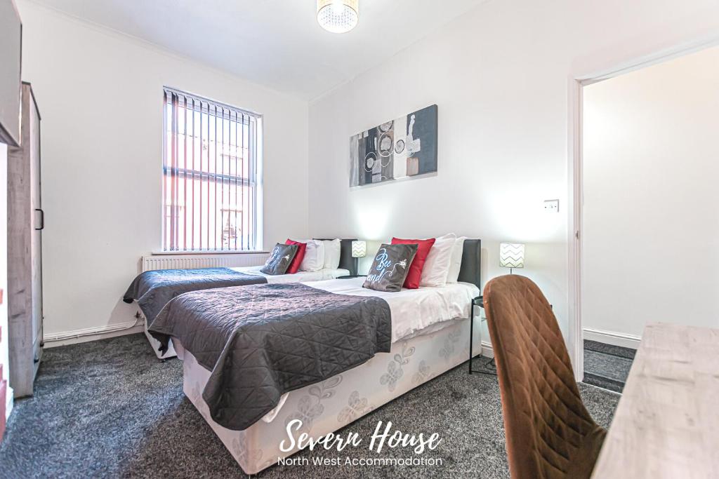 利Severn Street House Serviced Accommodation的一间卧室配有两张床和一张桌子