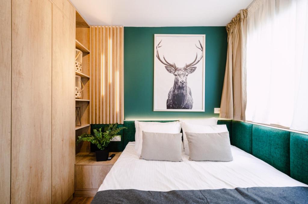 布什泰尼Moon Resort的一间卧室配有一张带绿色墙壁的床