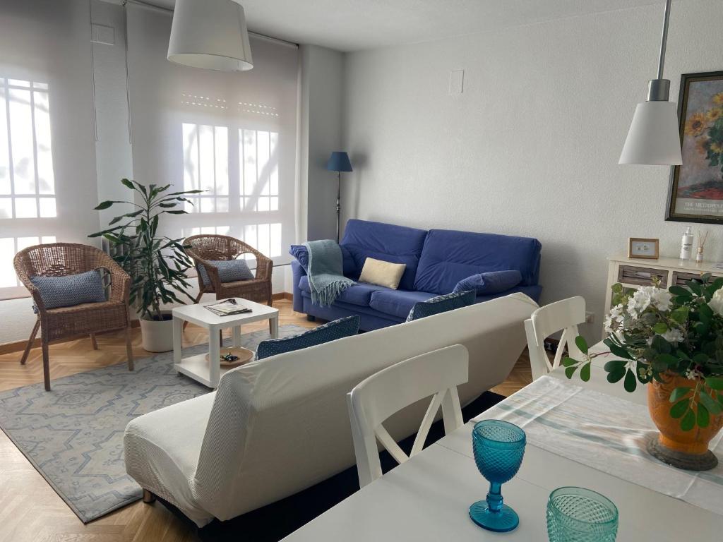 托莱多Casa San Juan de los Reyes的客厅配有蓝色的沙发和桌子