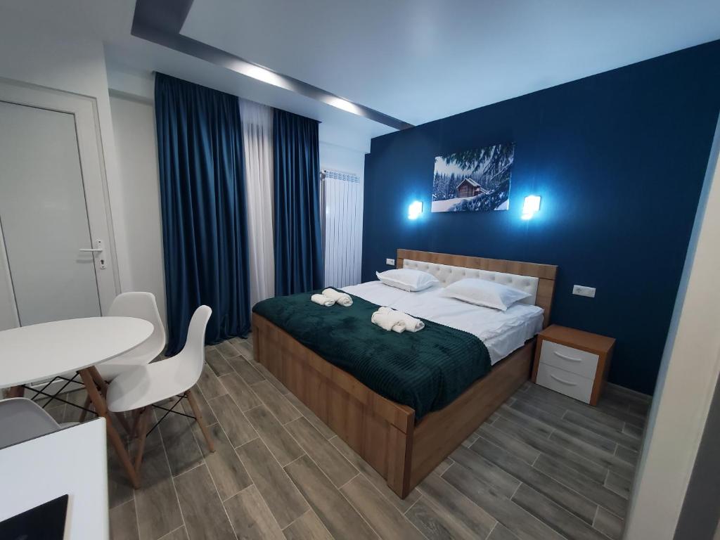 巴库里阿尼Bakuriani Mix Apartment 414的一间卧室设有一张床和蓝色的墙壁