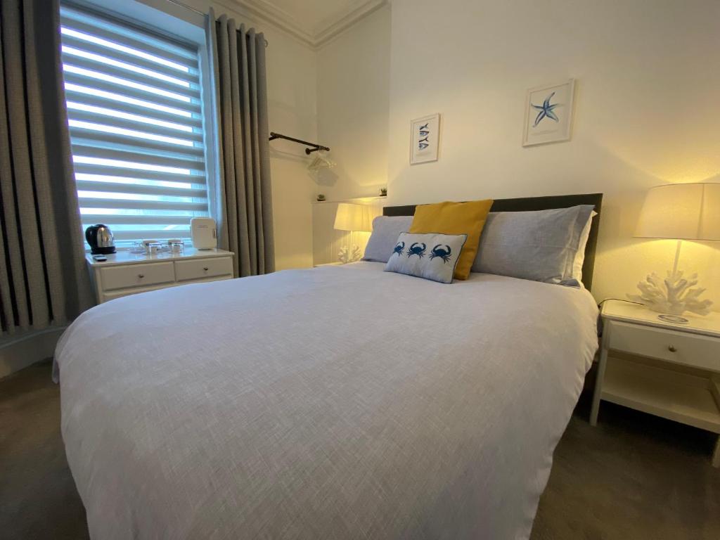 托基Rooms At Babbacombe的卧室设有一张白色大床和一扇窗户。