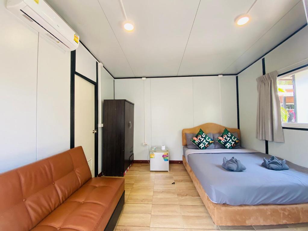 奈扬海滩KORA-GREAT Airport Phuket的一间卧室配有两张床和一张沙发。