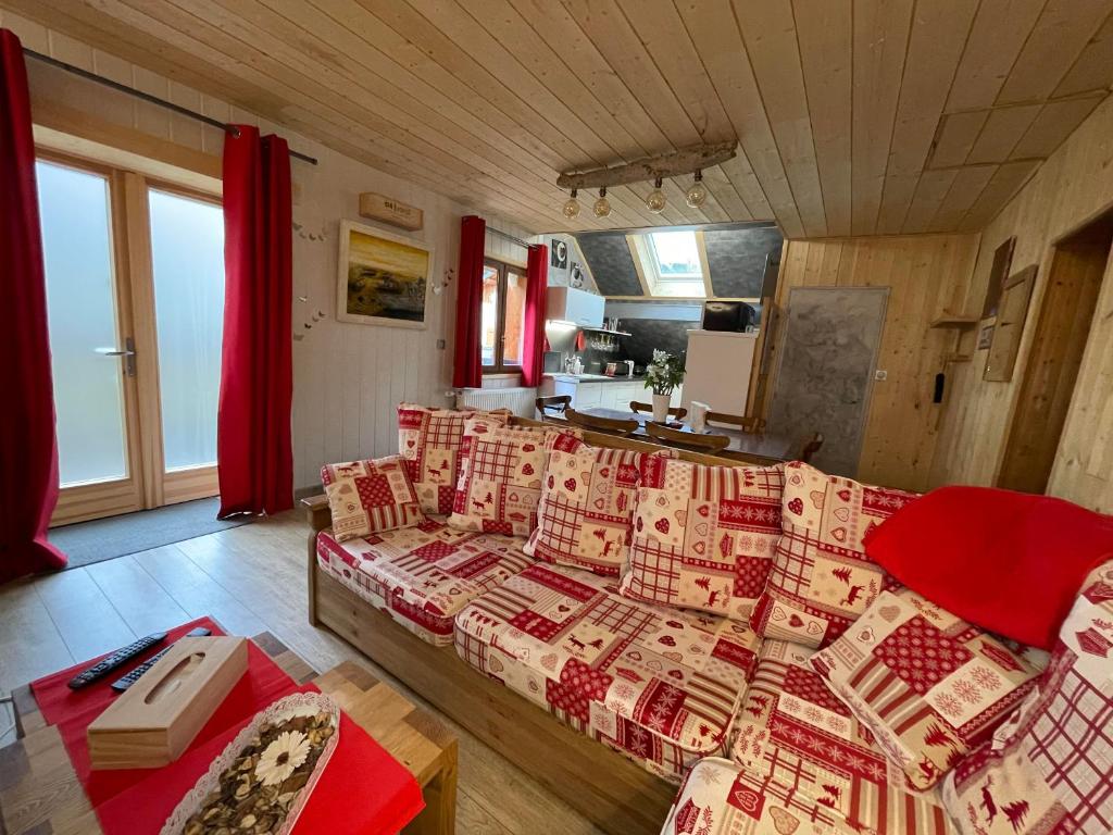 MontminMagnifique T3 entre lac et montagne près d'Annecy的带沙发和红色窗帘的客厅