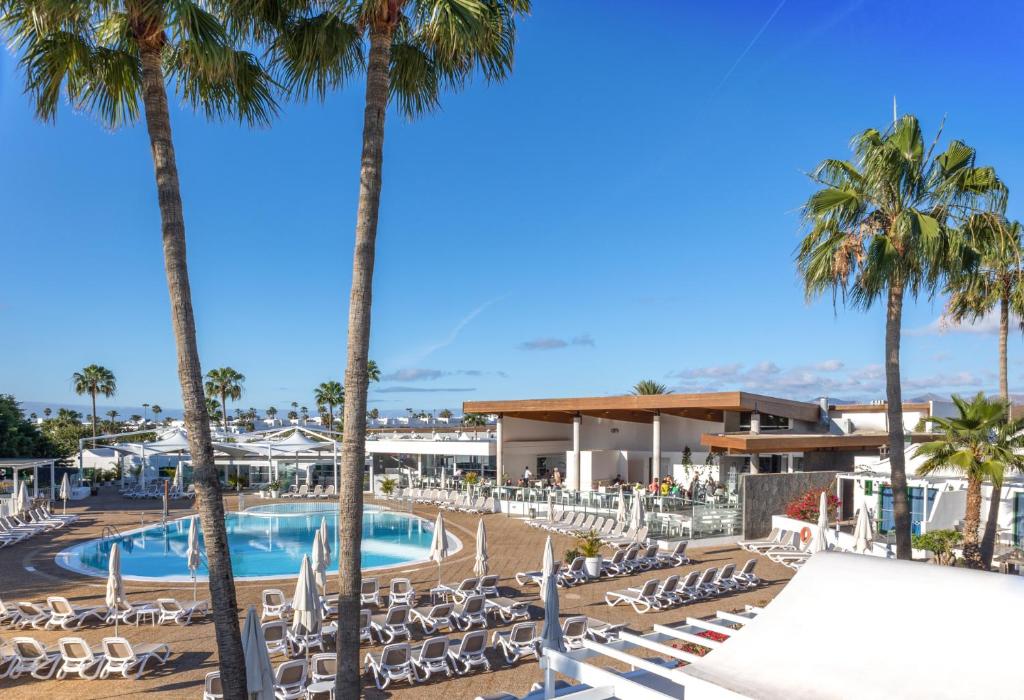 卡门港海德公园巷道酒店的一个带游泳池、椅子和棕榈树的度假村